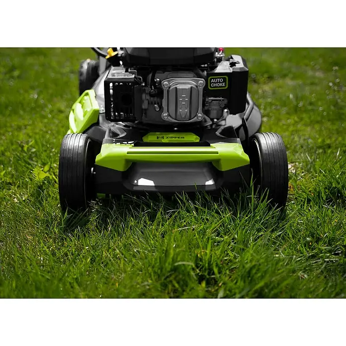 Zipper Benzin-Rasenmäher ZI-BRM52EST - 173 cm³, Schnittbreite: 52 cm - Frontansicht eines Rasenmähers auf grünem Gras. Der Rasenmäher hat grüne Akzente und einen silbernen Motorblock.