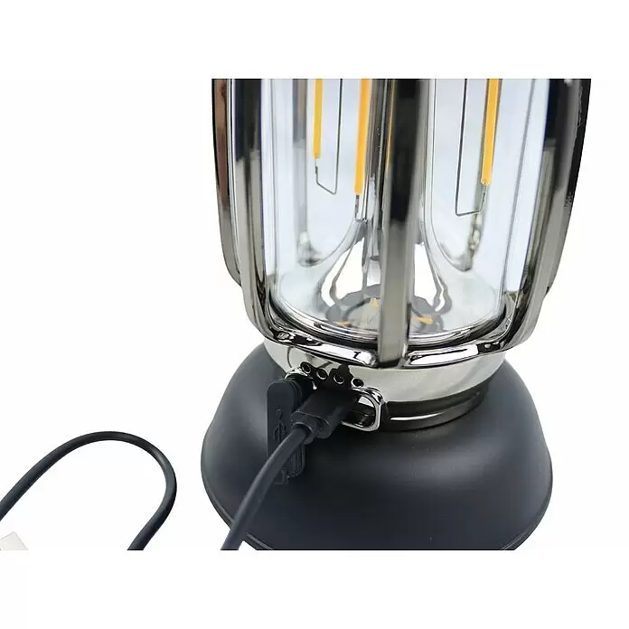Außenlaterne Lucerna - 11,3 x 11,3 x 17,2 cm, Schwarz - Eine LED-Laterne im Vintage-Stil mit schwarzem Sockel und silbernem Rahmen. Ein schwarzes USB-Kabel ist eingesteckt.