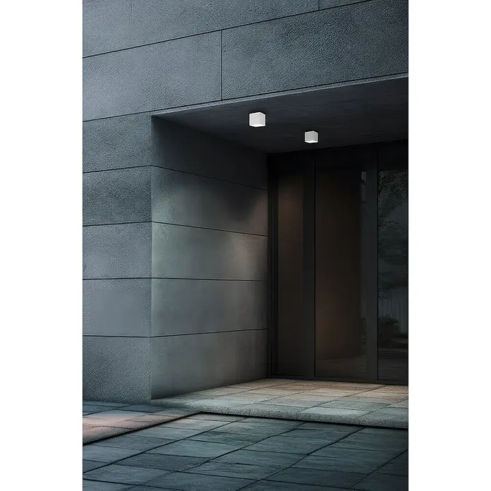Eglo Aplique exterior LED Barcarola-E - 4,5 W, 10,5 x 10,5 x 10 cm, Blanco, IP44, Blanco neutro - Toma exterior moderna de un edificio con iluminación exterior elegante que destaca el diseño arquitectónico.