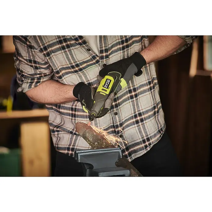 Ryobi Akku-Rotationswerkzeug RRT12-120BA335 - 12 V, 1 Akku, 2 Ah - Ein Mann benutzt einen Ryobi-Drehwerkzeug mit Schutzhandschuhen, um an einem in einem Schraubstock befestigten Holzstück zu arbeiten.