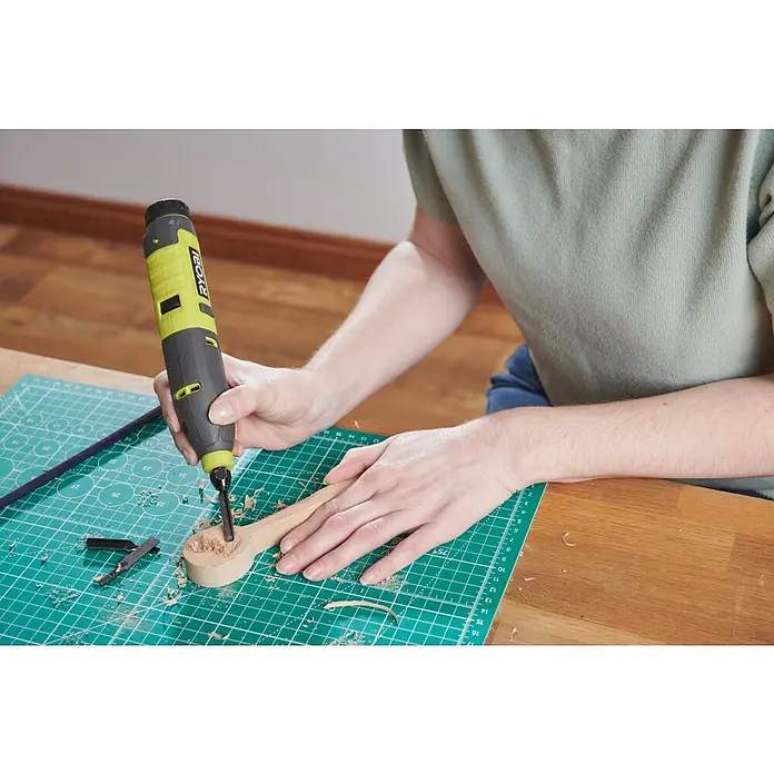 Ryobi Schnitzmesser RAR111-3 - 3 -tlg., Passend für: Ryobi 4V USB Akku-Schnitzer RPC4-120G - Nahaufnahme eines Ryobi-Drehwerkzeugs, das zum Bearbeiten eines Holzlöffels auf einer Schneidematte verwendet wird.