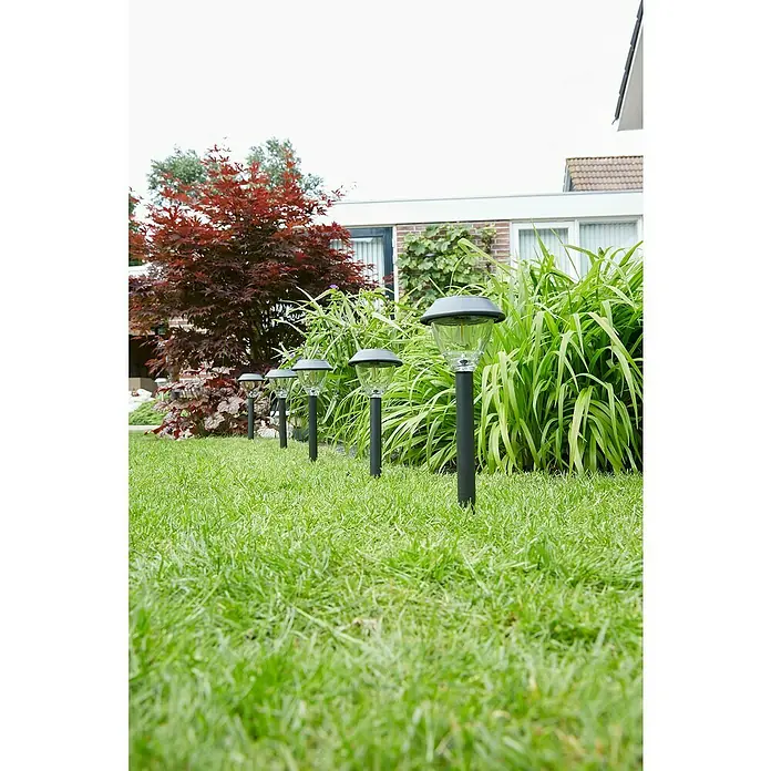 Luxform Solar-Erdspieß Kodiak - L x B x H: 11,5 x 11,5 x 43 cm, Anthrazit, IP44 - Reihe von Solarleuchten säumt einen üppigen grünen Rasen mit rotem Baum und Haus im Hintergrund. Die Lampen sorgen für stimmungsvolle Beleuchtung.