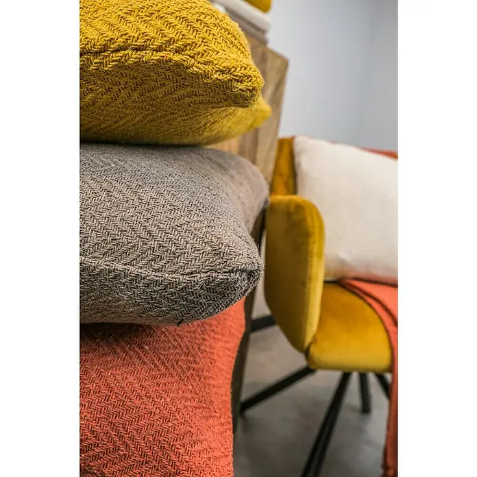 Kissen Kent - Pumpkin Orange, 45 x 45 cm, 100 % Baumwolle - Nahaufnahme von dekorativen Kissen in Gelb, Grau und Orange mit einem Webmuster, gestapelt auf einem Stuhl mit gelbem Samtbezug.