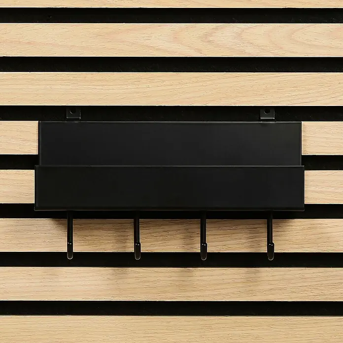 Millex Regal - L x B x H: 7 x 21,5 x 7 cm, Passend für: Akustikpaneele, Montageart: Einhängen - Nahaufnahme eines schwarzen Wandhakenleiste auf einer Holzpaneelwand, die ein modernes und stilvolles Aufbewahrungselement zeigt.