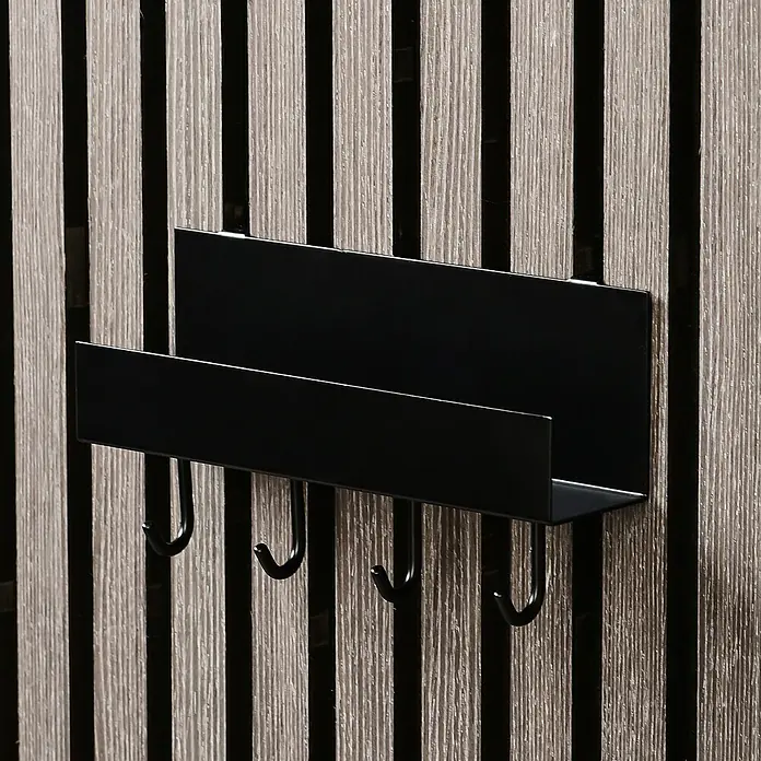 Millex Regal - L x B x H: 7 x 21,5 x 7 cm, Passend für: Akustikpaneele, Montageart: Einhängen - Ein schwarzer Metall-Wandorganizer mit Briefablage und Haken vor einer Wand mit Holzlatten.