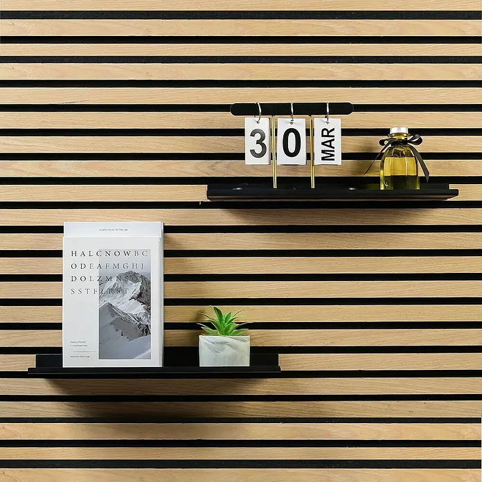 Millex Regal - L x B x H: 10 x 40 x 2,5 cm, Passend für: Akustikpaneele, Montageart: Einhängen - Wanddekoration mit Kalender, Duftöl und Buch auf schwebenden Regalen vor einer Holzpaneelwand.