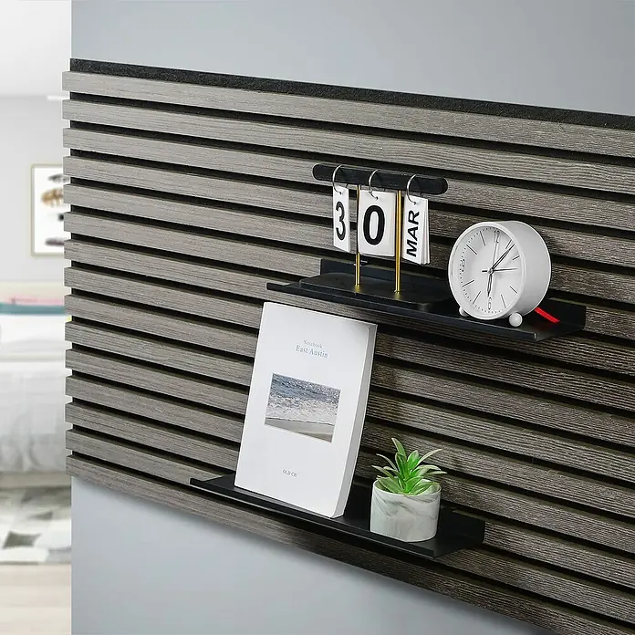 Millex Regal - L x B x H: 10 x 40 x 2,5 cm, Passend für: Akustikpaneele, Montageart: Einhängen - Nahaufnahme von zwei schwarzen Wandregalen mit Deko-Objekten. Das obere Regal enthält einen Kalender und eine Uhr, das untere ein Buch und eine Pflanze.