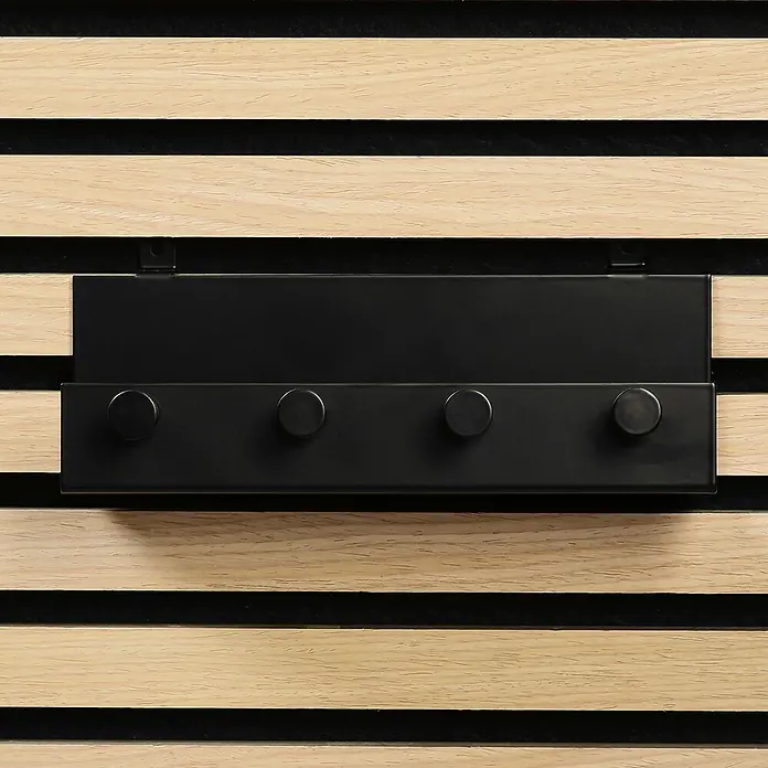 Millex Regal - L x B x H: 5 x 21,5 x 7 cm, Passend für: Akustikpaneele, Montageart: Einhängen - Eine Nahaufnahme einer schwarzen Wandgarderobe mit vier Knöpfen, die an einer Holzwand mit schwarzen Akzenten befestigt ist.