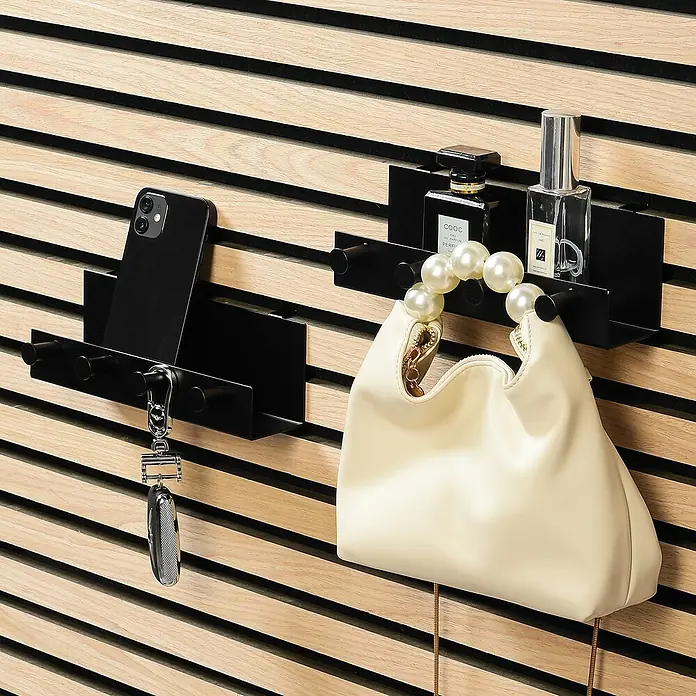 Millex Regal - L x B x H: 5 x 21,5 x 7 cm, Passend für: Akustikpaneele, Montageart: Einhängen - Schwarze Wandorganisatoren mit Handy, Schlüssel, Handtasche und Parfüm auf einer Holzpaneelwand.