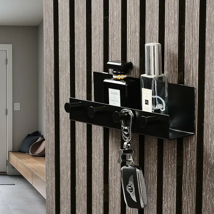 Millex Regal - L x B x H: 5 x 21,5 x 7 cm, Passend für: Akustikpaneele, Montageart: Einhängen - Eine schwarze Wandgarderobe mit Schlüsselanhänger, Parfümflaschen und einem minimalistischen Design, das Funktionalität und Stil vereint.