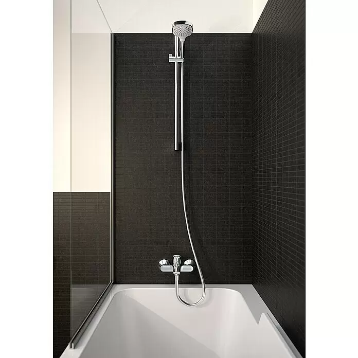 Hansgrohe Logis Grifo monomando de bañera - Profundidad del grifo: 194 mm, Cromo, Brillante - Bañera blanca con sistema de ducha cromado sobre azulejos de pared rectangulares oscuros.