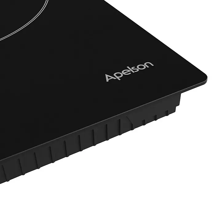 Apelson Set de horno y zona de cocción AMM 5001 X - Volumen horno: 73 l, Número de zonas de temperatura: 3 ud., Negro/Acero inoxidable - Primer plano de una placa de inducción negra Apelson que muestra su superficie lisa y su diseño minimalista.