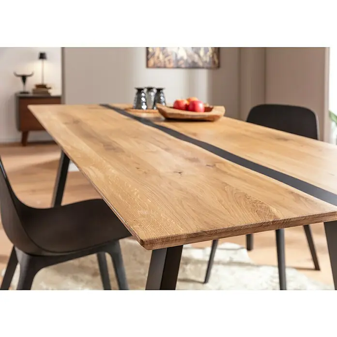 Exclusivholz Tischplatte Epoxid - Eiche, 200 x 85 x 2,6 cm - Nahaufnahme eines Esstisches mit Holzplatte und dunkler Harzlinie, umgeben von modernen schwarzen Stühlen für stilvolles Ambiente.