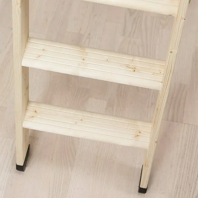 Dolle Bodentreppe Easy Loft - 120 x 70 cm, Wärmedämmung: 1.099 W/(m²K) - Eine Nahaufnahme einer hellen Holzleiter mit drei Stufen und schwarzen Fußkappen, die auf einem hellen Holzboden steht.