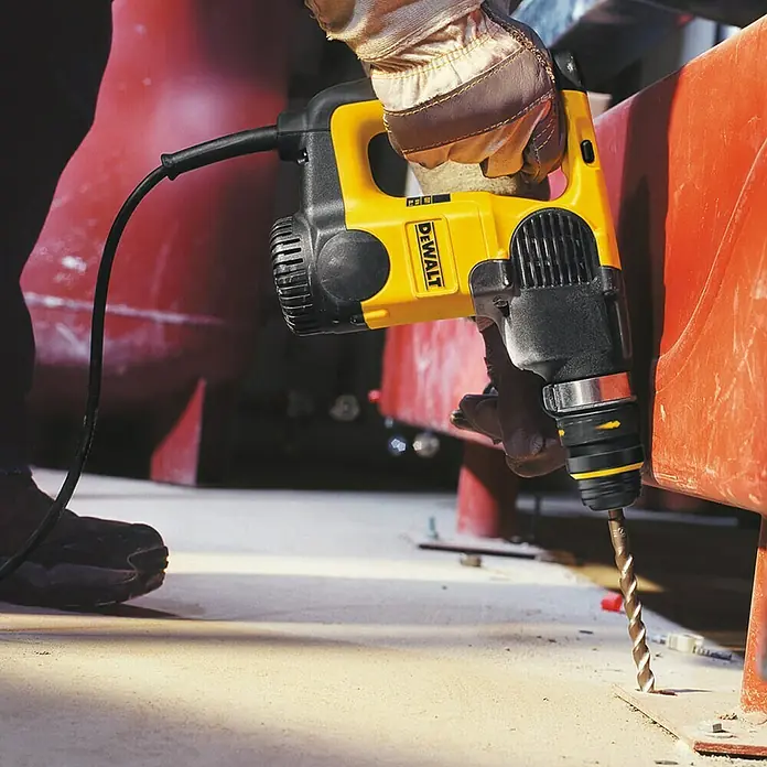 DeWalt Broca para hormigón y mampostería DT9530-QZ - 1 ud., Diámetro de la broca: 8 mm - Primer plano de un martillo perforador DeWALT amarillo utilizado por una persona con guantes para perforar hormigón.