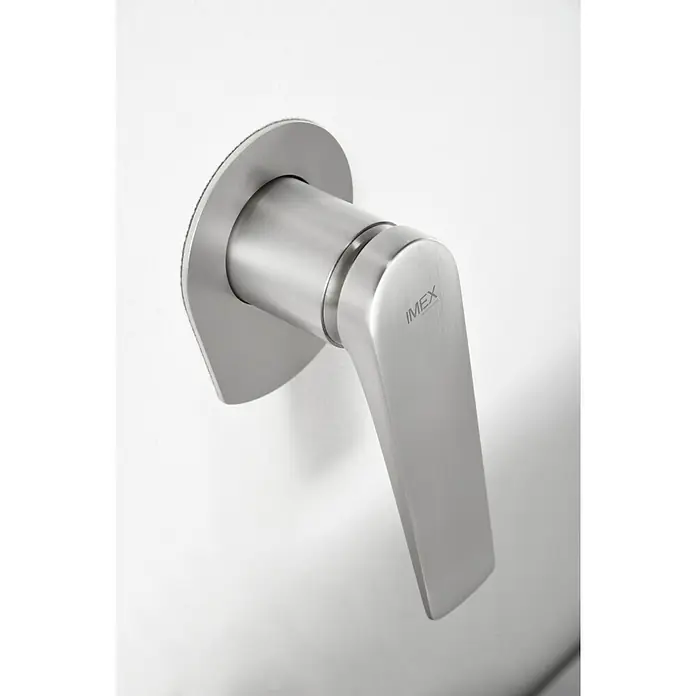 Imex Delos Grifo de lavabo - Acero - Primer plano de un grifo mezclador monomando IMEX en acero inoxidable cepillado, montado en una pared blanca, mostrando un diseño moderno y minimalista.