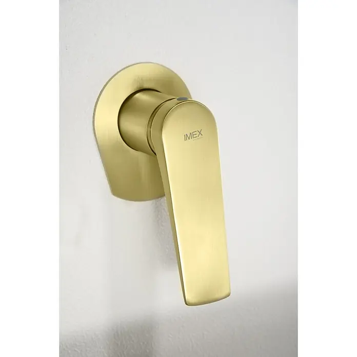 Imex Delos Grifo de lavabo - Oro - Primer plano de un grifo IMEX dorado montado en una pared, mostrando su diseño elegante y moderno.