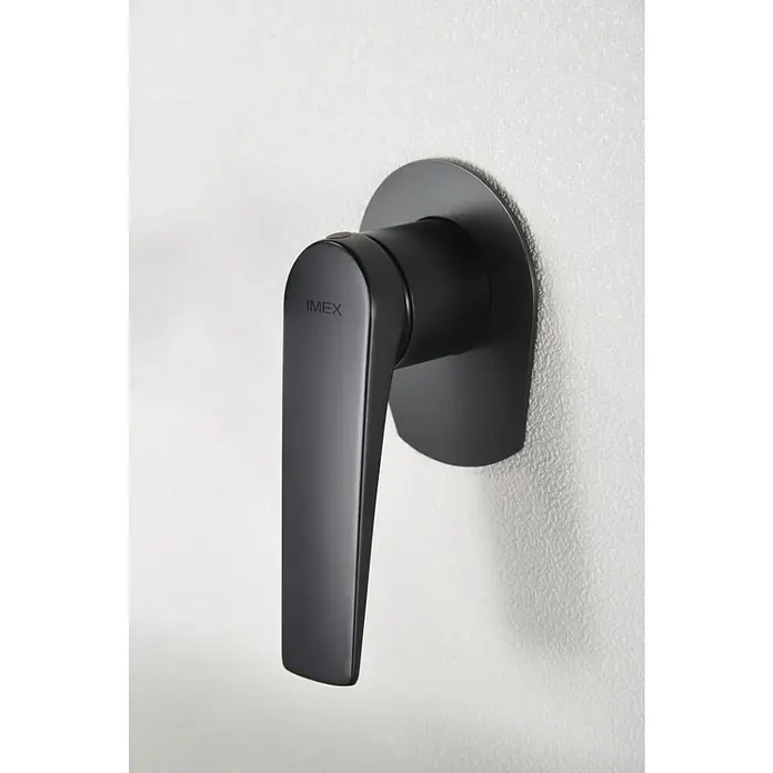 Imex Delos Grifo de lavabo - Negro - Primer plano de un elegante grifo IMEX negro montado en una pared blanca, que muestra un diseño y funcionalidad modernos.