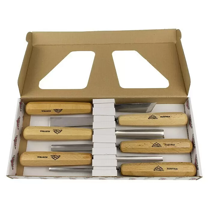 Stubai Stechbeitelsatz - 6 -tlg. - Set von Stubai Holzbildhauer-Werkzeugen mit hellen Holzgriffen und Metallklingen, ordentlich in einer offenen Kartonschachtel arrangiert.