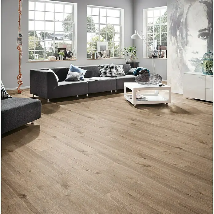 Krono Original Laminat Organic Classic Eurus Oak1.288 x 195 x 8 mm, Landhausdiele, Eurus Oak - Helles Laminat verleiht diesem Wohnzimmer einen modernen Look. Es passt gut zu den grauen Möbeln und dem minimalistischen Dekor.