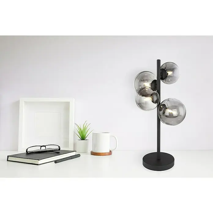 Globo Lámpara de sobremesa Riha - L x An x Al: 270 x 230 x 510 mm, G9 - Primer plano de una lámpara de mesa moderna con cuatro globos de vidrio, sobre un escritorio con decoración minimalista.