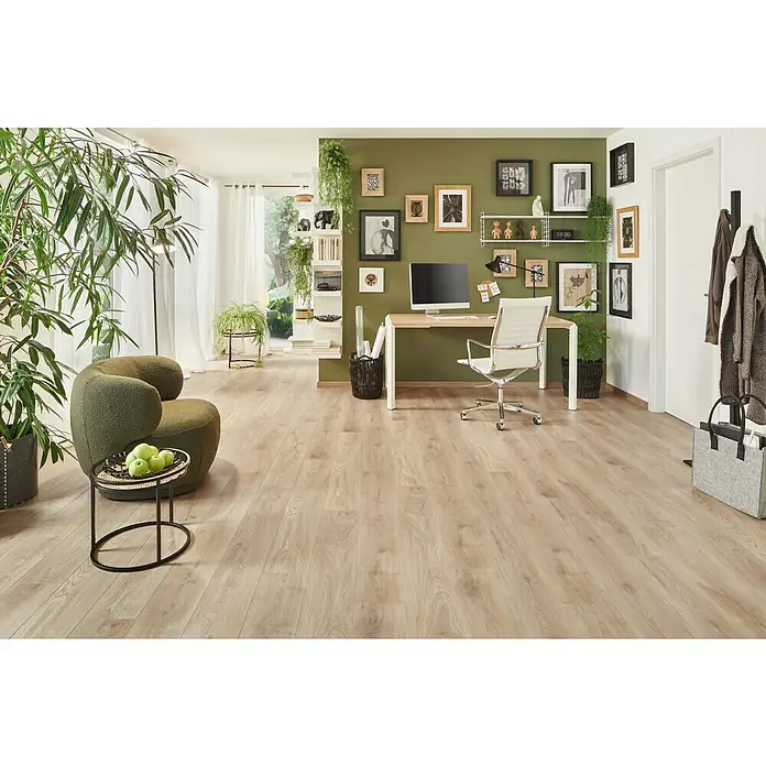 LOGOCLIC Ambienta Laminat - Honig Eiche, Landhausdiele, 1.288 x 195 x 10 mm - Einladender Raum mit hellem Holzboden, grünem Sessel, Schreibtisch und Pflanzen für eine harmonische Atmosphäre.