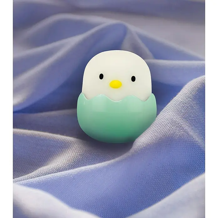 MegaLight LED-Nachtlicht BABY EGGY - 3 Stk., 0,2 W, L x B x H: 5 x 5 x 5,7 cm, RGBW, BABY EGGY - Nahaufnahme eines Kükenförmigen Nachtlichts mit LED-Lichtern, das auf einem drapierten lilafarbenen Stoff sitzt.