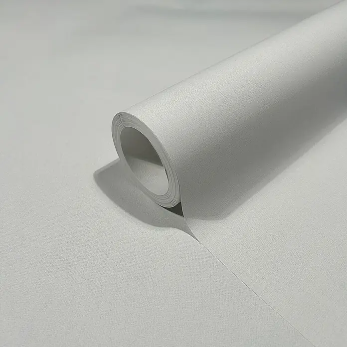 Marburg Heritage Vliestapete Glatte Struktur - Grün, Uni, 10,05 x 0,53 m - Nahaufnahme einer Rolle neutralgrauer Vliestapete, ideal für ein minimalistisches und modernes Raumambiente.