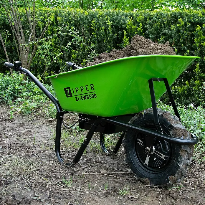 Zipper Akku-Schubkarre ZI-EWB500 - 500 W, Material Wanne: Stahl, Traglast: 150 kg - Eine grüne, elektrisch betriebene Schubkarre von Zipper, Modell ZI-EWB500, beladen mit Erde, steht im Garten.