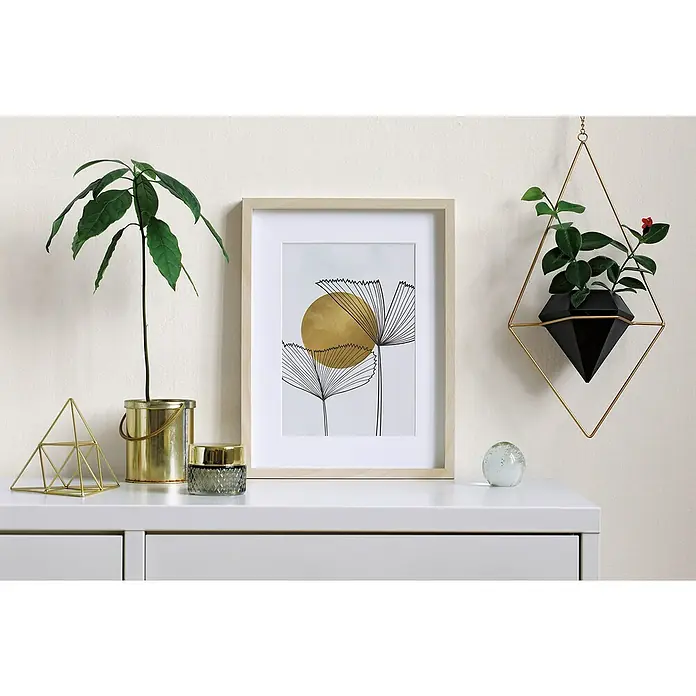 Marburg Heritage Vliestapete Glatte Struktur - Beige, Uni, 10,05 x 0,53 m - Dekorative Inneneinrichtung mit einem gerahmten abstrakten Kunstwerk, einer Zimmerpflanze und goldenen Akzenten auf einer weißen Kommode.