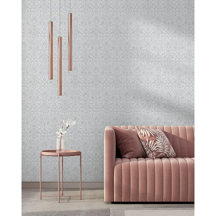 Marburg Heritage Vliestapete Allover mit Tieren & Blumen - Weiß/Grau, Floral, 10,05 x 0,53 m - Elegantes Interieur mit einer zartrosa Couch, einem Beistelltisch mit Blumen und stilvollen Pendelleuchten vor einer dezent gemusterten Tapete.