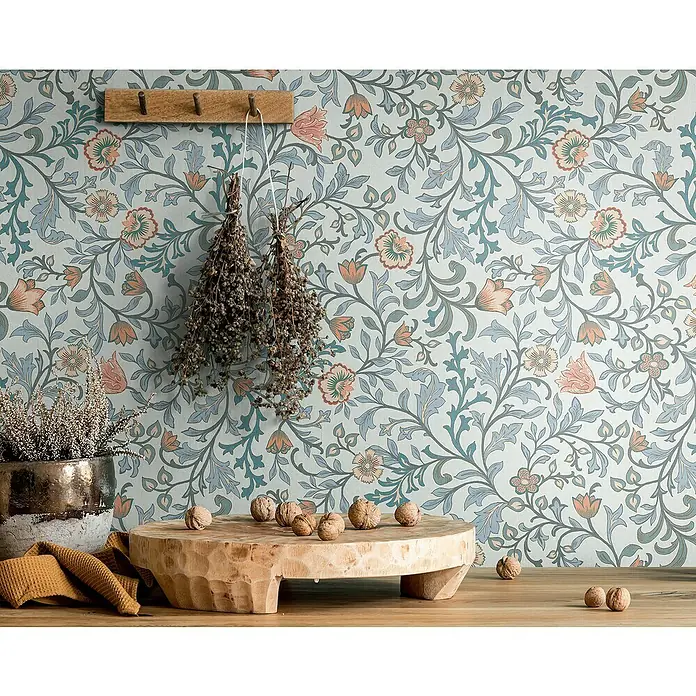Marburg Heritage Vliestapete Blumenallover - Blau, Floral, 10,05 x 0,53 m - Nahaufnahme einer dekorativen Wand mit floralem Tapetenmuster, einem Holzbrett mit Nüssen und einem Hängegestell.