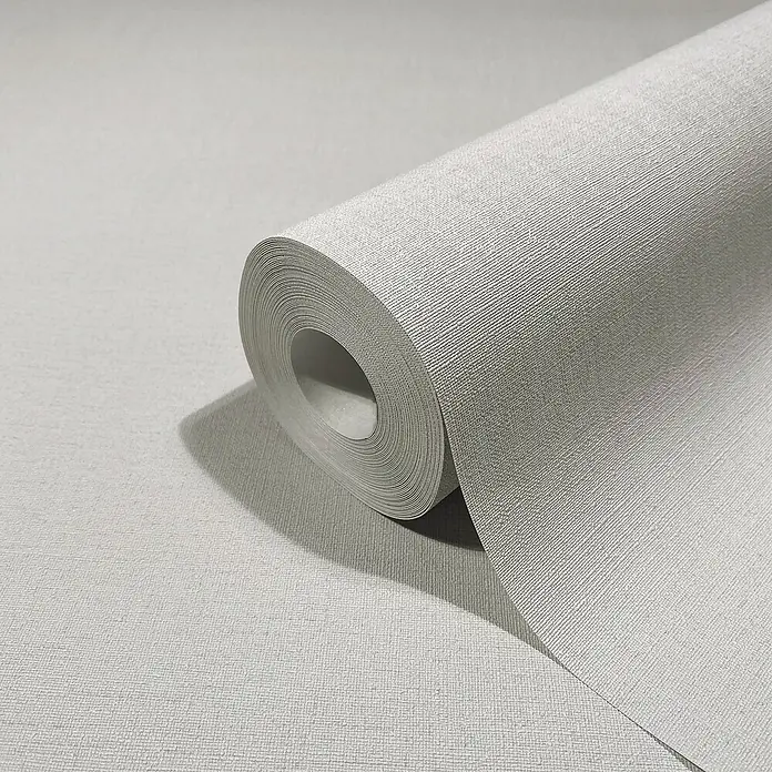 Marburg Struktura Vliestapete Kylie - Grau, Uni, 10,05 x 0,53 m - Nahaufnahme einer Rolle grauer, strukturierter Tapete. Ideal für moderne Innenräume, die Wert auf schlichte Eleganz und hochwertige Materialien legen.