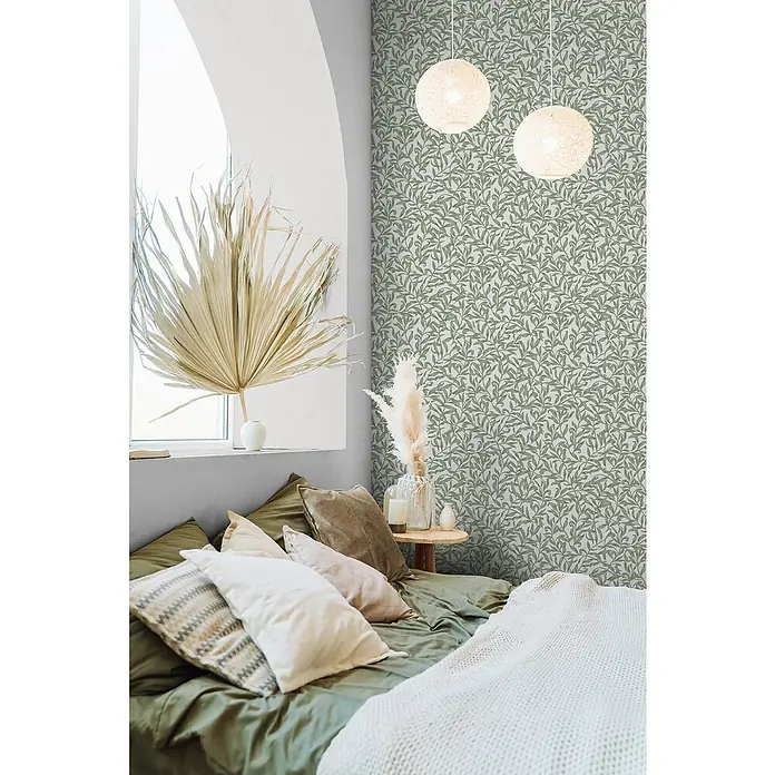 Marburg Heritage Vliestapete Blätterranken-Allover - Grün/Grau, Floral, 10,05 x 0,53 m - Ein Schlafzimmer mit einer Akzentwand mit botanischem Tapetenmuster, das eine ruhige und stilvolle Atmosphäre schafft.