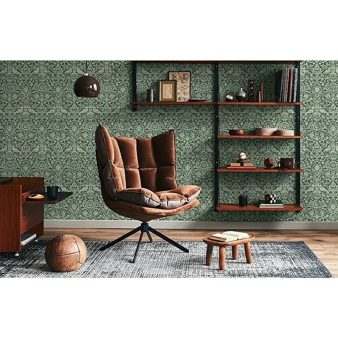 Marburg Heritage Vliestapete Allover mit Tieren & Blumen - Grün, Floral, 10,05 x 0,53 m - Bild eines modernen braunen Sessels mit hoher Rückenlehne, der auf einem gemusterten Teppich in einem stilvollen Interieur steht.