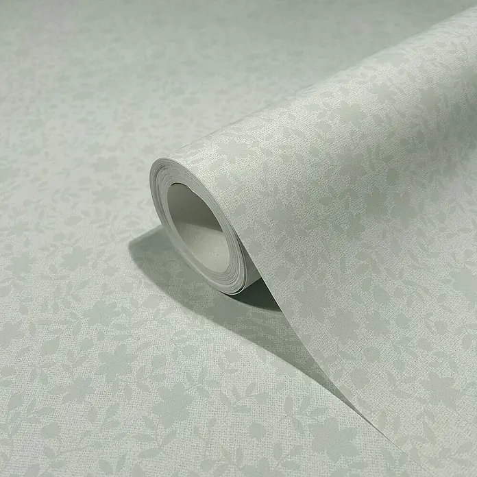 Marburg Heritage Vliestapete mit feinen Blättern - Blau, Floral, 10,05 x 0,53 m - Nahaufnahme einer Rolle blassgrüner Tapete mit subtilem Blumenmuster, die eine elegante und dezente Wanddekoration zeigt.