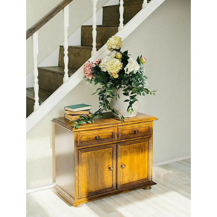 Marburg Heritage Vliestapete mit feinen Blättern - Beige, Floral, 10,05 x 0,53 m - Elegantes Sideboard aus Holz mit Blumenstrauß und Büchern, das den Raum mit seinem Charme bereichert.