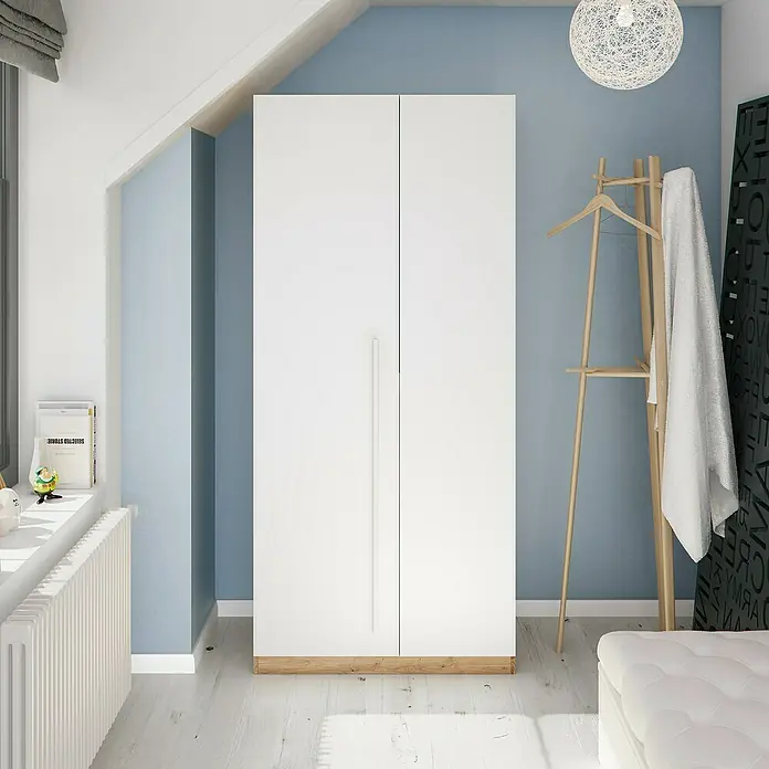 Armario para ropa y cama Noa - Roble Nodi/Blanco Artik - Imagen de un armario blanco de dos puertas con base de madera, en una habitación azul claro.