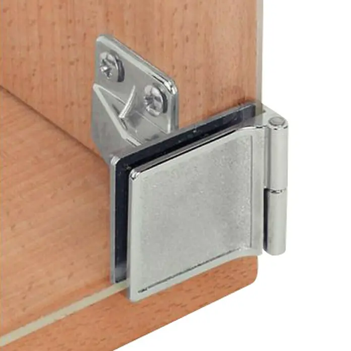 Stabilit Herraje para puerta de vidrio - Niquelado - Primer plano de una bisagra de vidrio sujeta a una puerta o armario de madera, proporcionando un soporte seguro para superficies de vidrio.