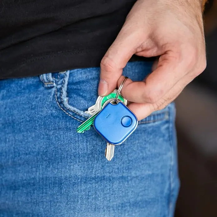 Shelly Schalter BLU Button1 - Blau, Batteriebetrieben - Schlüsselanhänger mit blauem Tile Tracker am Schlüsselbund in einer Jeanshosentasche.