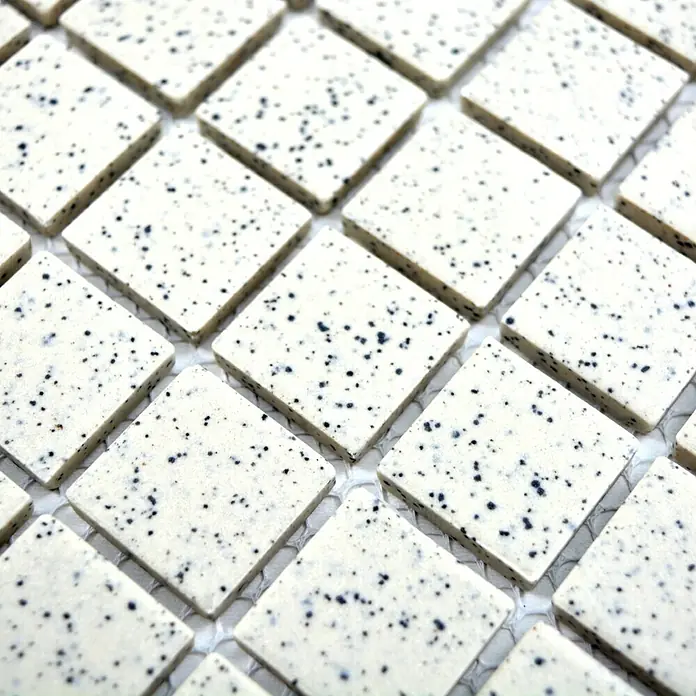 Mosaikfliese Quadrat Uni CU QR208 - 33 x 30,2 cm, Cremeweiß, Matt - Eine Nahaufnahme von quadratischen Mosaikfliesen in einem hellen Farbton mit dunklen Sprenkeln, ideal für moderne Raumgestaltungen.
