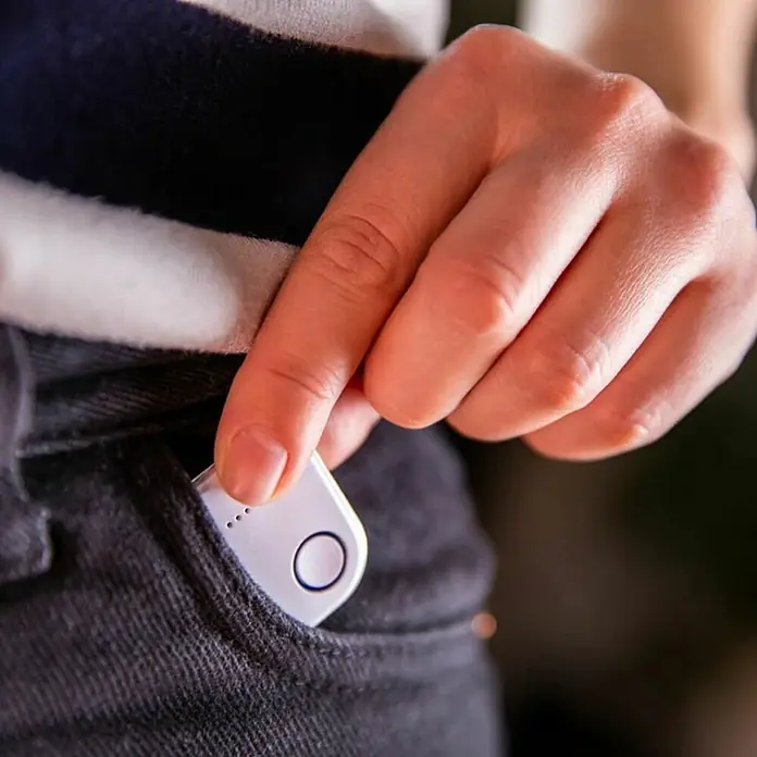 Shelly Schalter BLU Button1 - Weiß, Batteriebetrieben - Nahaufnahme einer Person, die einen weißen Flipper Zero in eine schwarze Hosentasche steckt.