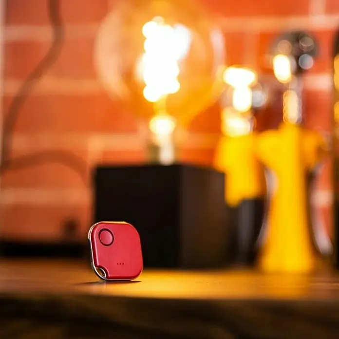 Shelly Schalter BLU Button1 - Rot, Batteriebetrieben - Ein roter Smart Tracker auf einem Tisch, ideal zum Auffinden von Schlüsseln oder Gepäck. Kompaktes Design für den täglichen Gebrauch.