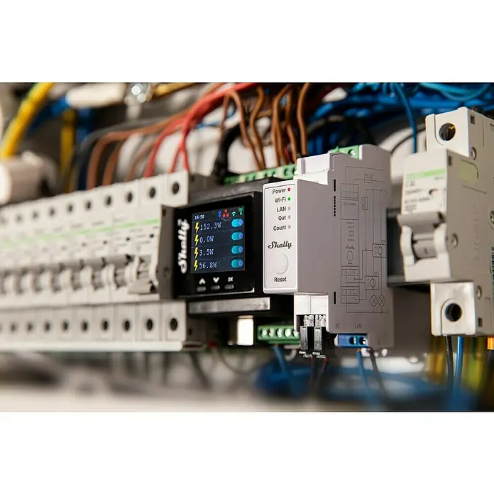 Shelly Wechselstromzähler Pro EM - 50 - 50 A, 110 V - 240 V - Nahaufnahme eines Shelly Smart Home Geräts, das Stromverbrauch und Netzwerkinformationen anzeigt, eingebaut in einen Stromkasten.