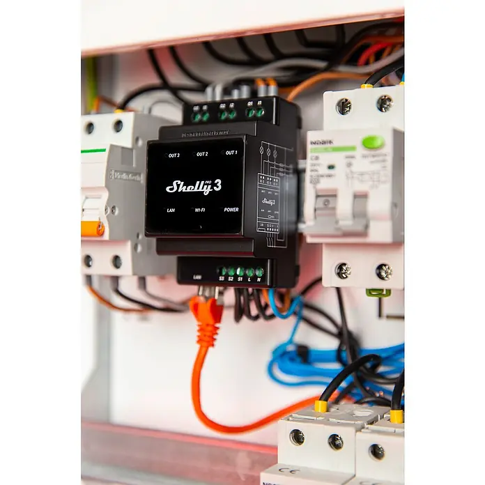 Shelly Relais-Modul Pro 3 - 110 V - 240 V, 48 A - Nahaufnahme eines Shelly Pro 3 Smart Home Geräts in einem Schaltschrank, verbunden mit Kabeln und anderen elektrischen Komponenten.