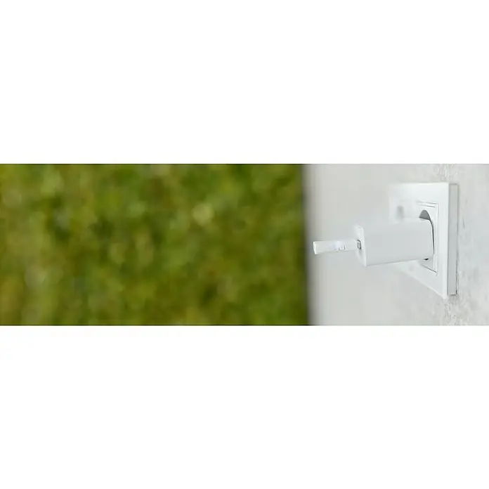 Shelly Gateway BLU - 2.400 MHz - 2.483,5 MHz - Nahaufnahme eines weißen USB-Ladegeräts, das an eine weiße Steckdose angeschlossen ist, mit einem grünen, verschwommenen Hintergrund.