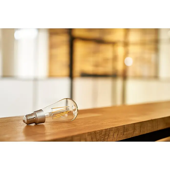 Shelly Smart-LED-Lampe Vintage ST64 - E27, Dimmbar, Warmweiß, 750 lm, 7 W - Elegante LED-Glühbirne im Vintage-Stil auf einer Holzoberfläche, die warmes Licht und dekorativen Charme für jeden Raum bietet.