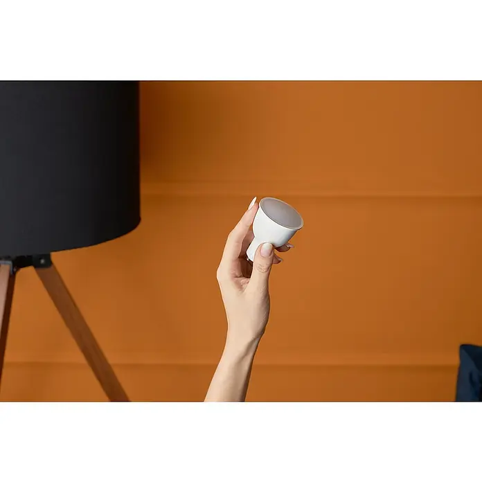 Shelly Smart-LED-Lampe Duo - RGBW GU10 - GU10, Dimmbar, Warmweiß, 400 lm, 5 W - Nahaufnahme einer Hand, die eine LED-Lampe hält, die moderne Beleuchtungslösung für ein gemütliches Ambiente verspricht.
