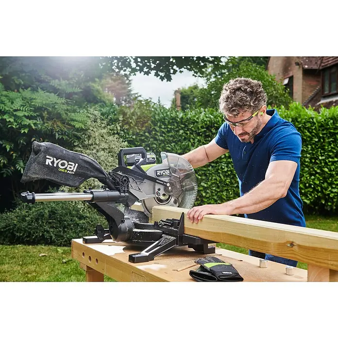 Ryobi ONE+HP Akku-Kapp- & Gehrungssäge RMS25418X-0 - 18 V, Ohne Akku, 4.100 U/min - Ein Mann benutzt eine Ryobi ONE+ HP Kapp- und Gehrungssäge, um ein Holzstück zu schneiden. Der Mann trägt dabei eine Schutzbrille.