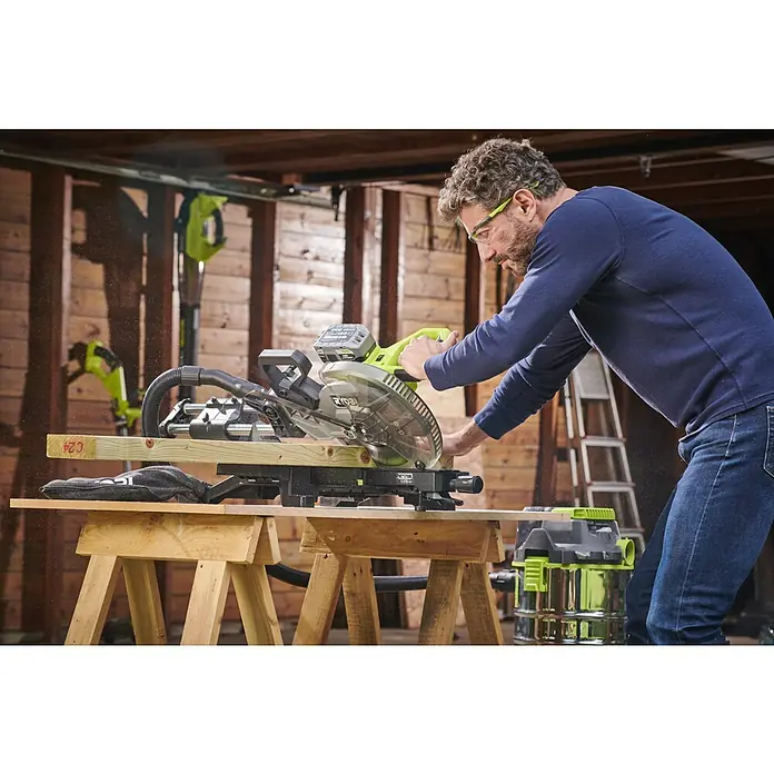 Ryobi ONE+HP Akku-Kapp- & Gehrungssäge RMS25418X-0 - 18 V, Ohne Akku, 4.100 U/min - Ein Mann arbeitet mit einer Ryobi Kapp- und Gehrungssäge, um Holz auf einem Baugerüst zu schneiden. Seine Schutzbrille schützt ihn während der Arbeit.